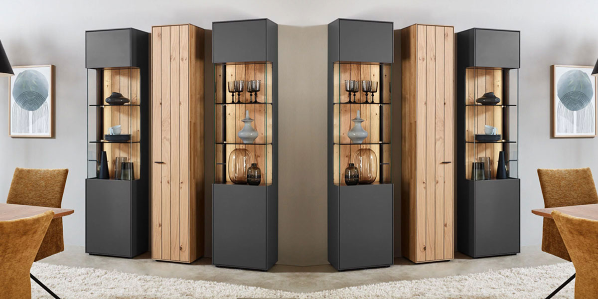 Wöstmann Zeilenschränke Entdecken Sie die perfekte Kombination aus Funktionalität und Design mit den Zeilenschränken von Wöstmann, ob Stauraum oder Dekorative Vitrine. Banner zeigt 3 Zeilenschränke, zwei als Vitrine mit einer Lamellen-Rückwand, eines als reines Stauraumwunder.